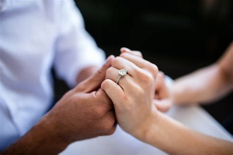 Premium Photo Close Up Of Couple Holding Hands With Engagement Ring