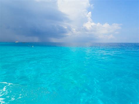 The Water Is Very Blue And Clear Under A Cloudy Sky