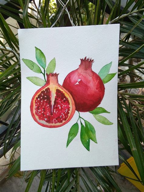 A Painting Of Two Pomegranates With Green Leaves
