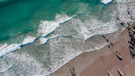 Download Wallpaper 1366x768 Calm Beach Waves Rocks Green Sea In