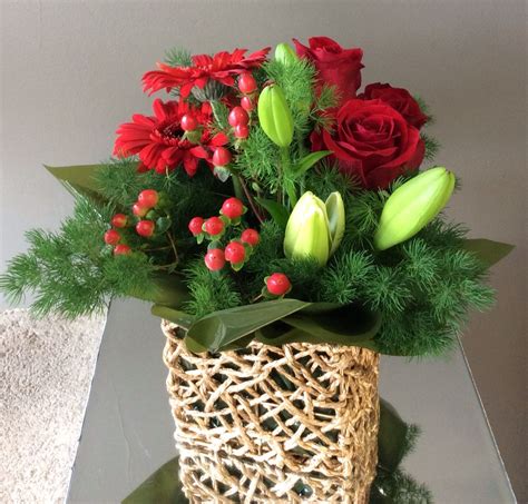 A Christmas Arrangement With White Lillies Red Roses Hypericum