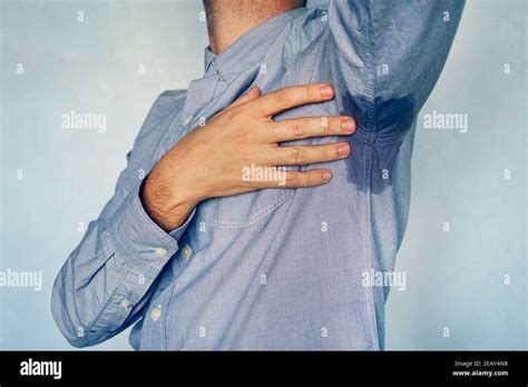 Man With Hyperhidrosis Sweating Very Badly Under Armpit In Blue Shirt