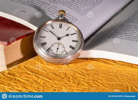 Antique Silver Pocket Watch On Background Of An Open Book With Text