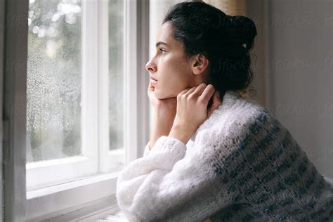 Beautiful Brunette Woman Standing Near A Window During A Rainy Day