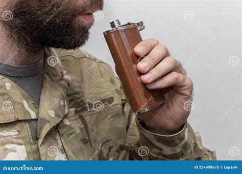 A Soldier In Military Uniform Brings A Flask To His Mouth Concept