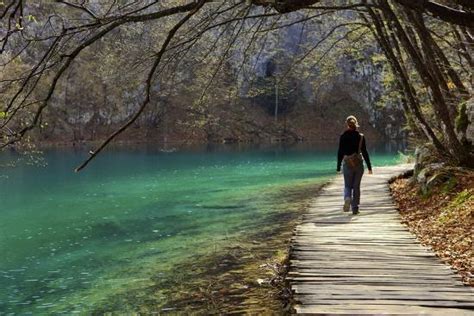 Visitor On Wooden Walkway Path Over Crystal Clear Waters Of Plitvice