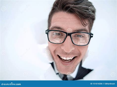 Young Businessman Breaking Through A White Paper Wall Stock Photo