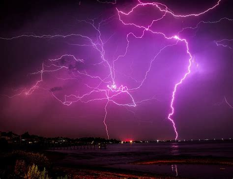 Purple Lightning Strikes Over The Ocean At Night