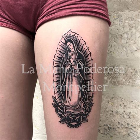 A Womans Thigh With A Tattoo Of The Virgin Mary In Black And White