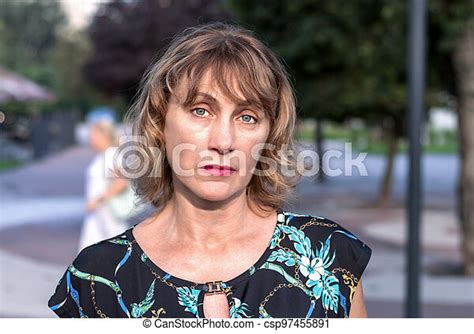 portrait of a beautiful mature woman of middle age 50 years old with blond hair with a pensive