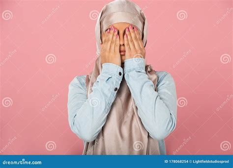 Scared Muslim Girl In Hijab Closing Eyes Isolated On Pink Stock Photo