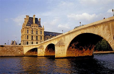 When the river is high, the branches of the weeping willow planted in cobblestones at the tip of the square caress the surface of the seine. Seine Bridge Paris Photograph by Buddy Mays