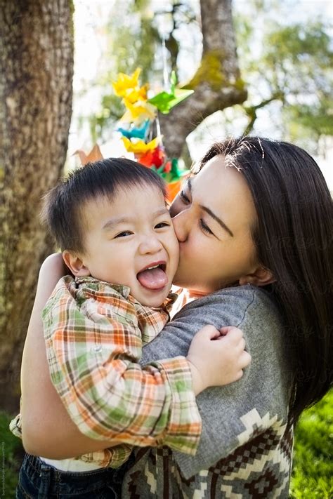Asian Mother Kissing Her Happy And Cute Son By Stocksy Contributor
