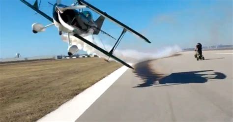 Crazy Bi Plane Stunt Sees Aircraft Fly Within Feet Of Cameraman On