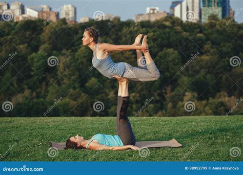 Two Caucasian Women Doing Yoga Stretching Workout In Park Outdoors At