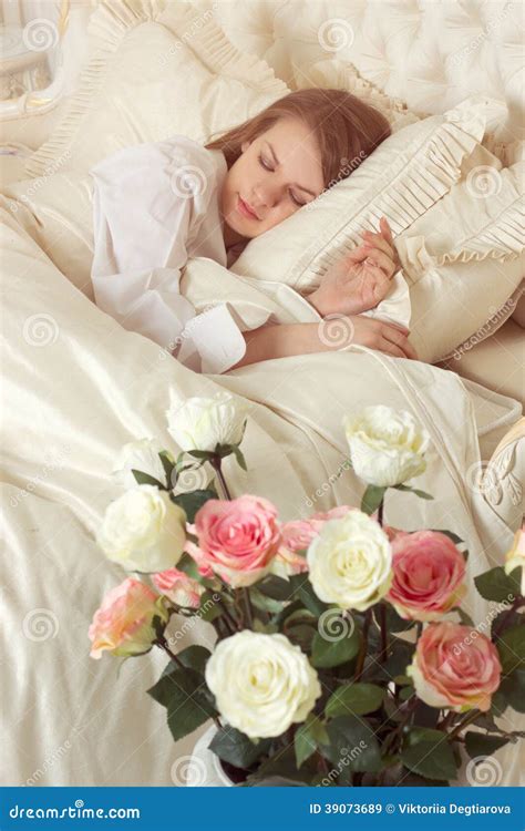 Mujer Durmiente Hermosa En Cama Con Las Rosas Imagen De Archivo