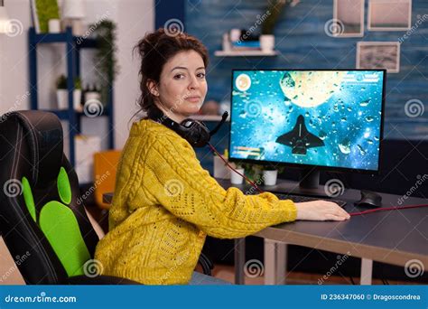 Portrait Of Woman Gamer Sitting At Desk Playing Space Shooter