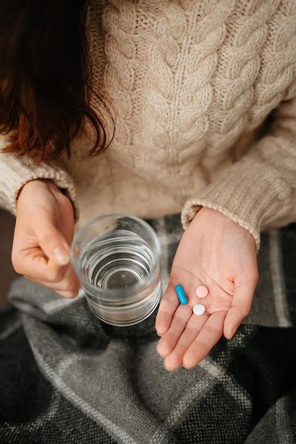 Premium Photo Woman Holds In Her Hands Glass Of Water And Pills For