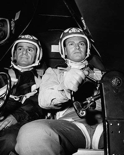 Black And White Photograph Of Two Men Sitting In A Race Car One