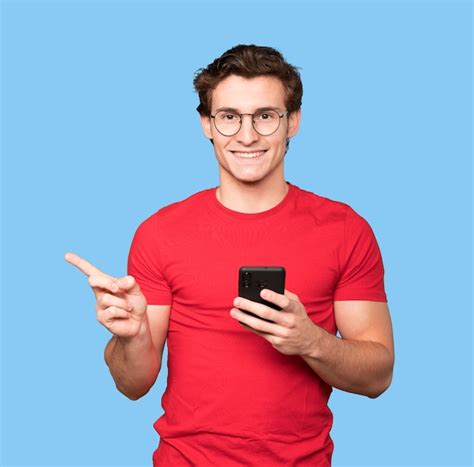 Premium Photo Happy Young Man Pointing Up And Using A Mobile Phone