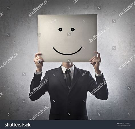 Young Businessman Hiding His Face With A White Billboard With A Smiley