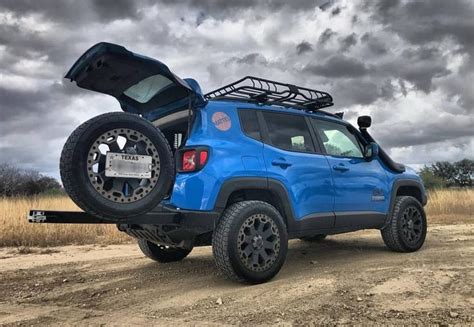 A Blue Jeep Parked On Top Of A Dirt Road