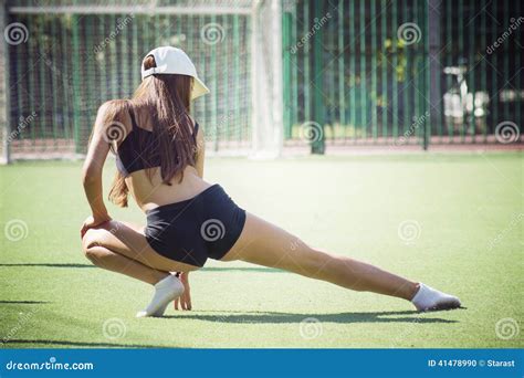 Молодая женщина приниманнсяый за фитнес на зеленой траве Стоковое Фото изображение