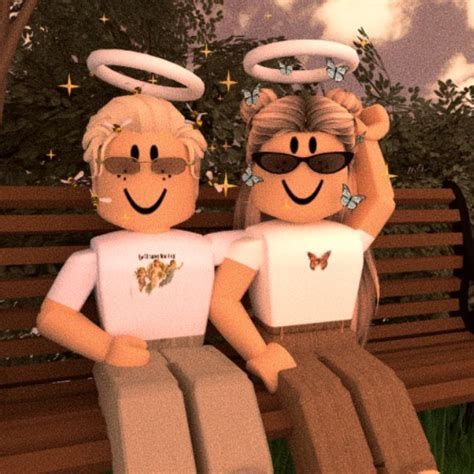 Two People Are Sitting On A Bench With Angel Wings Above Their Heads