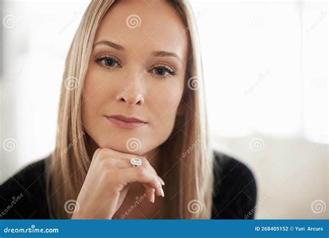 Pretty And Pensive Portrait Of A Young Woman Sitting With Her Hand On
