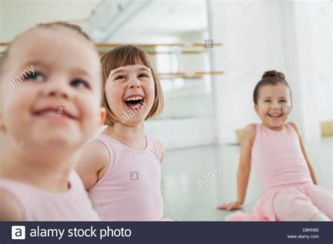 Smiling Children Doing Stretching Exercises In Ballet Studio Stock