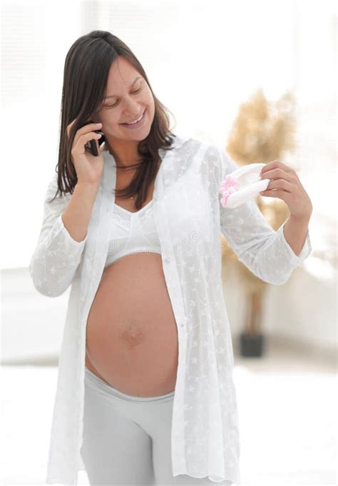 Mujer Embarazada Sonriente Que Habla En Su Smartphone Imagen De Archivo Imagen De Muchacha