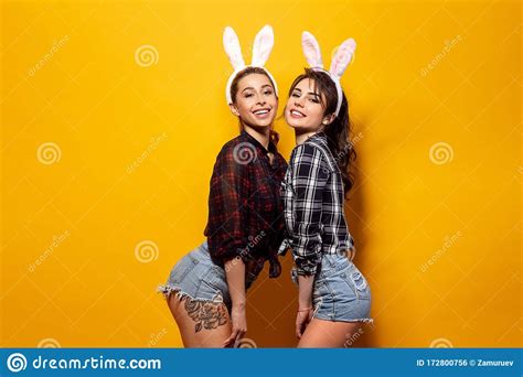 Two Young Caucasian Woman Wearing Cute Easter Rabbit Ears Over Yellow