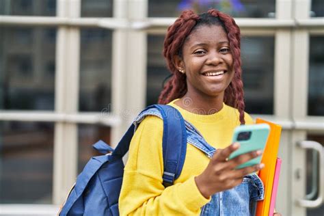 African American Woman Student Smiling Confident Using Smartphone At