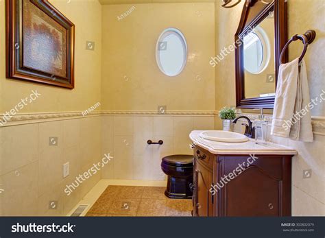 Classy Half Bathroom With Small Oval Window And Beige Tile Floor
