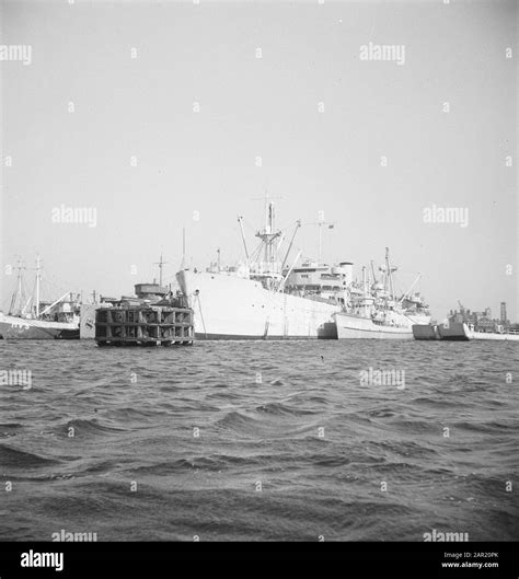 Cargo Ship Flanked By Naval Ships And Landing Vessels In Port Date 19