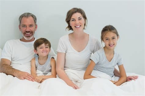 Familia Feliz Sentados Juntos En La Cama En El Dormitorio En Casa