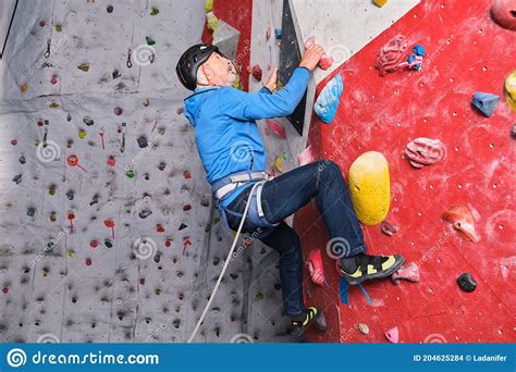 Professional Senior Man Climbing On An Artificial Rock Climbing Wall