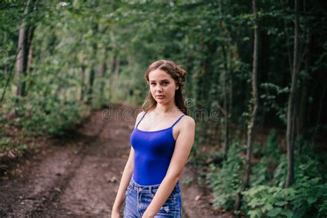Beautiful Girl In Short Shorts And A Blue T Shirt In The Woods Stock