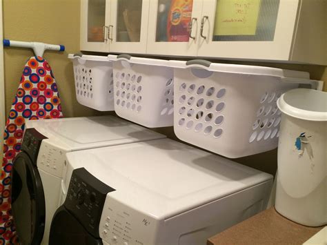 Hanging, slide-out laundry baskets for sorting in a small laundry room gambar png