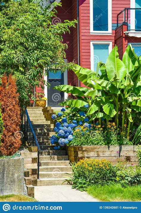 Entrance Of Suburban House With Landscaped Terraces And Blue Sky