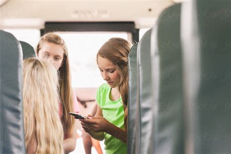 School Bus Girls On Bus Talking And Using Cell Phone By Stocksy Contributor Sean Locke