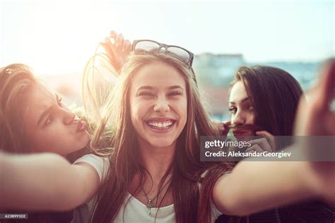 Group Of Smiling Girls Taking Funny Selfie Outdoors At Sunset Stockfoto Getty Images