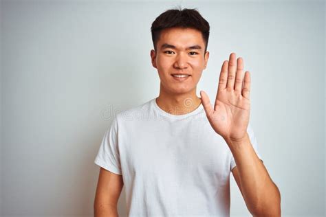 Young Asian Chinese Man Wearing T Shirt Standing Over Isolated White