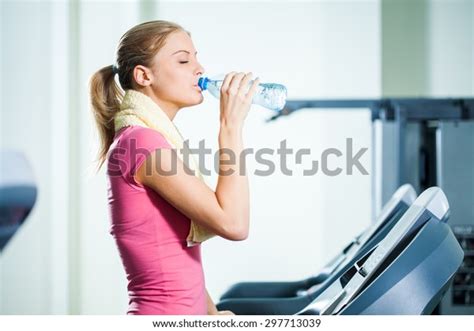Young Woman Drinking Water While Exercising Stock Photo 297713039