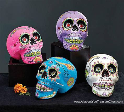 Three Brightly Colored Skulls Sitting On Top Of A Black Table Next To