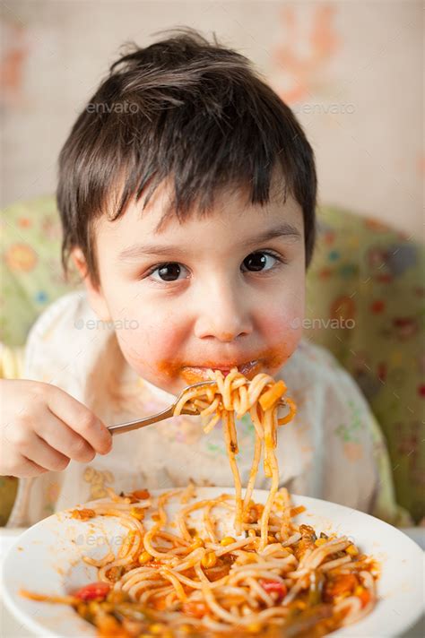 Child Eating Spaghetti With Vegetables Kid Having Fun Eating Stock
