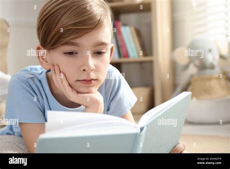 Little Boy Reading Book On Floor At Home Stock Photo Alamy