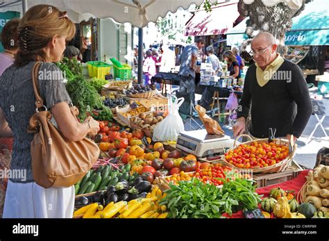 Market Trader Selling Fruit And Vegetables To Lady At Saturday Open Air