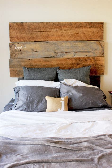 A Bed With Two Pillows On It And A Headboard Made Out Of Wooden Planks