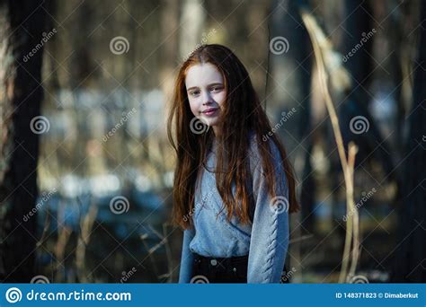 Beautiful Teen Girl With Long Hair Posing For A Portrait In A Pine